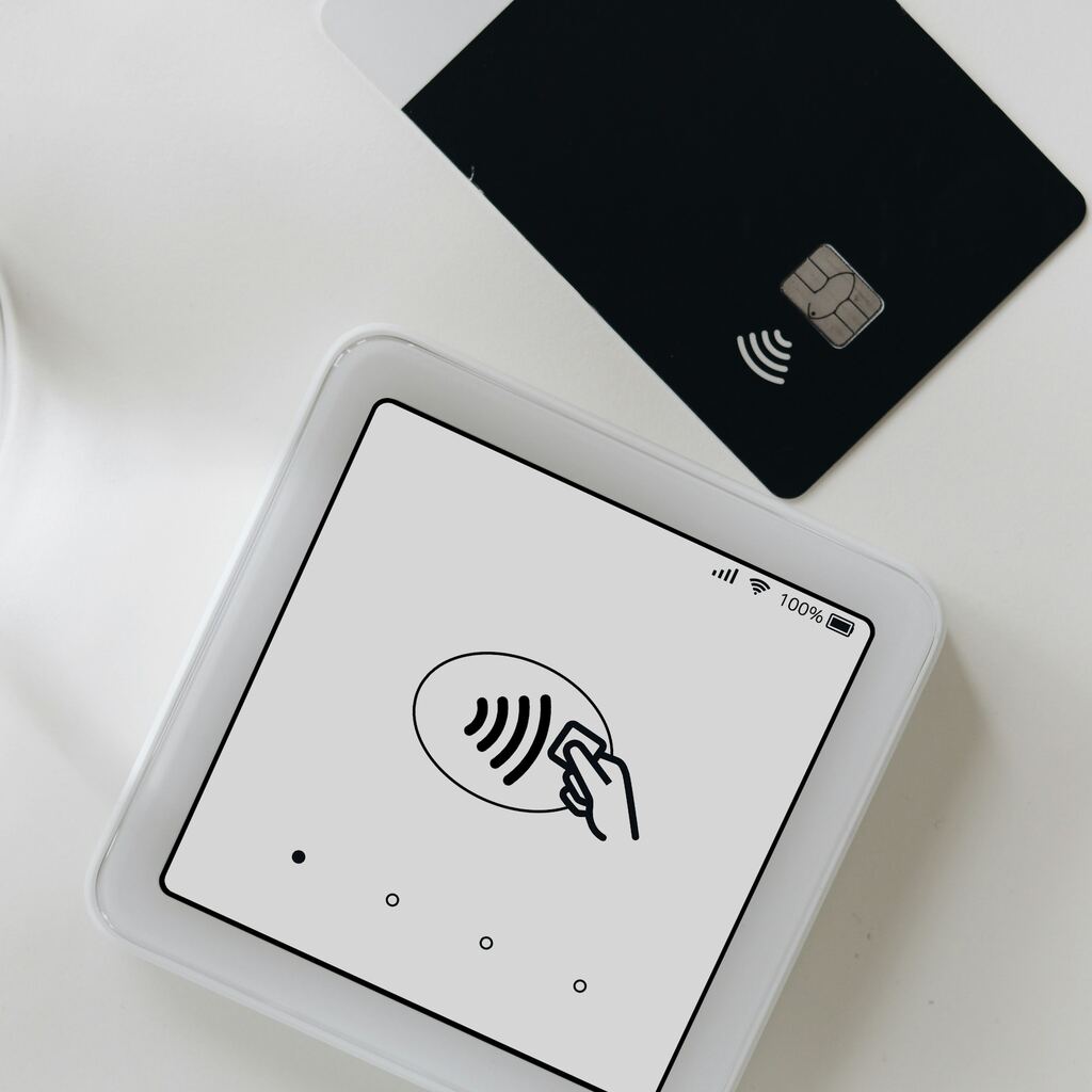Contactless payment terminal and black card representing Algeria PSP fintech regulation
