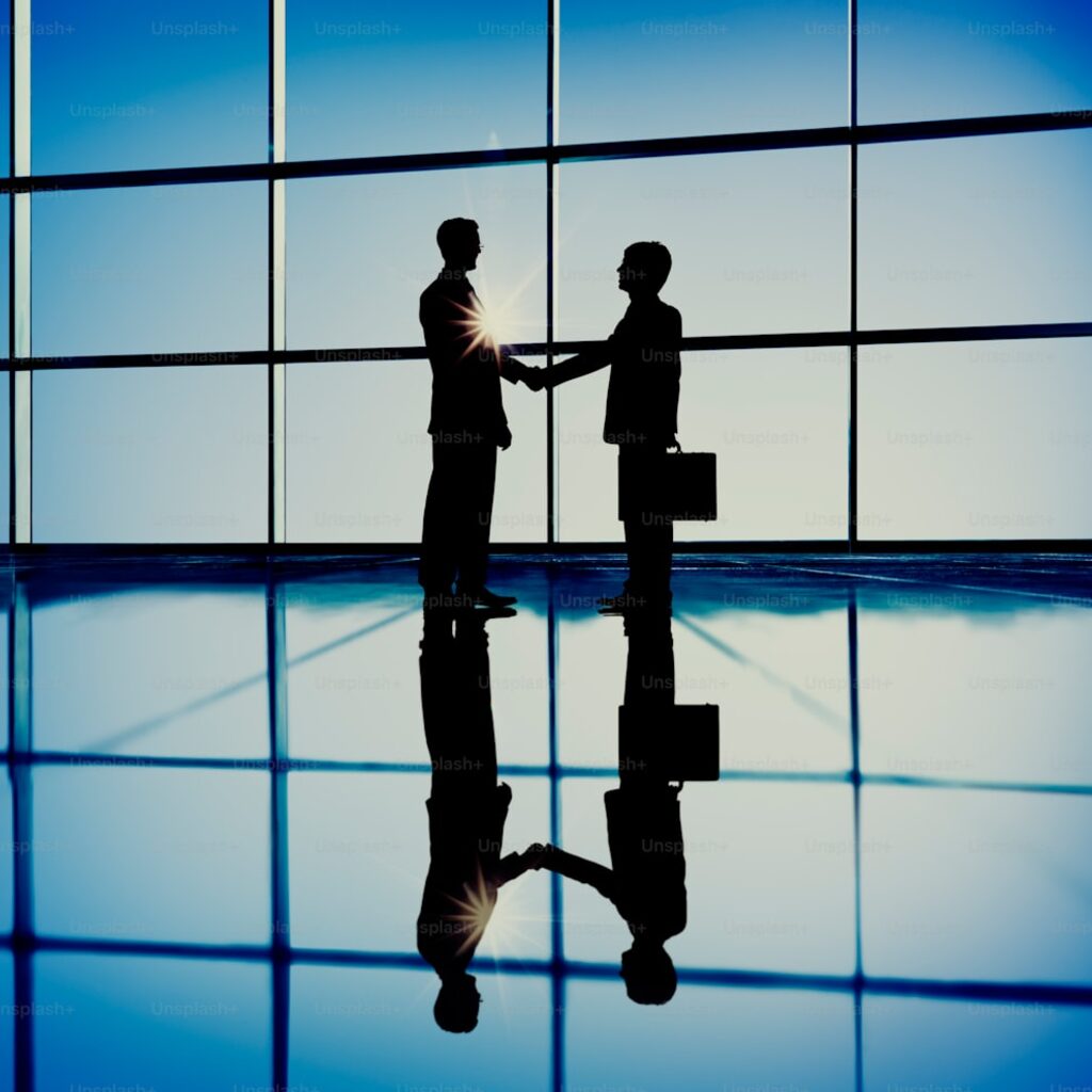 Business handshake representing M&A and foreign acquisition of Algerian startups